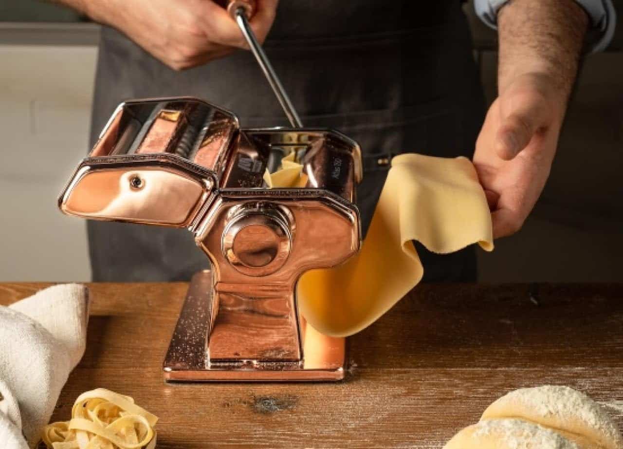 Une personne qui utilise une machine à pâtes.