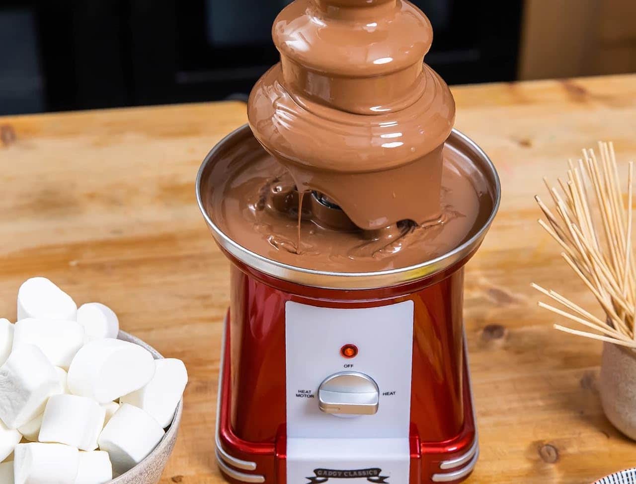 Une fontaine à chocolat sur une table en bois.