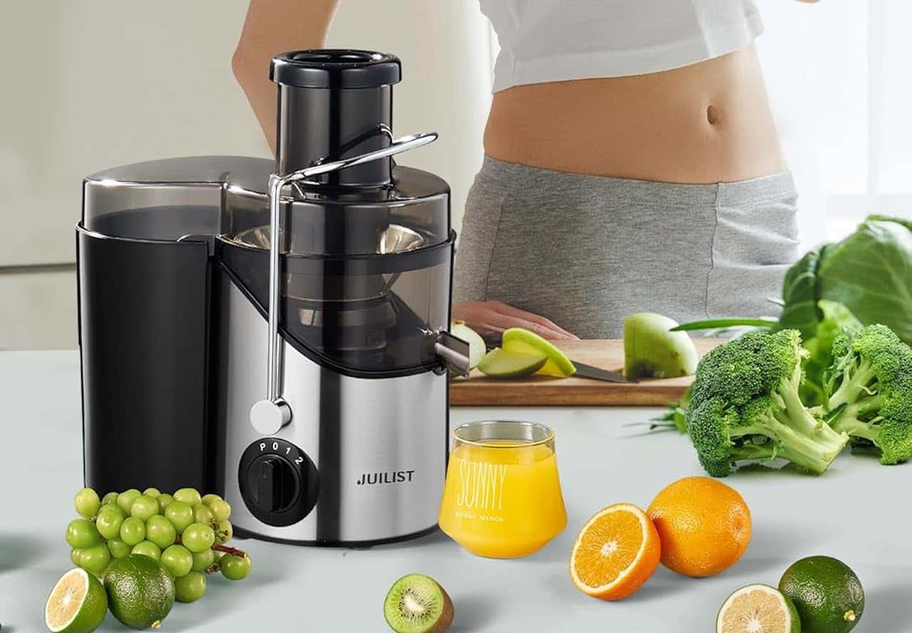 Une femme se prépare un jus à l'aide d'une centrifugeuse.