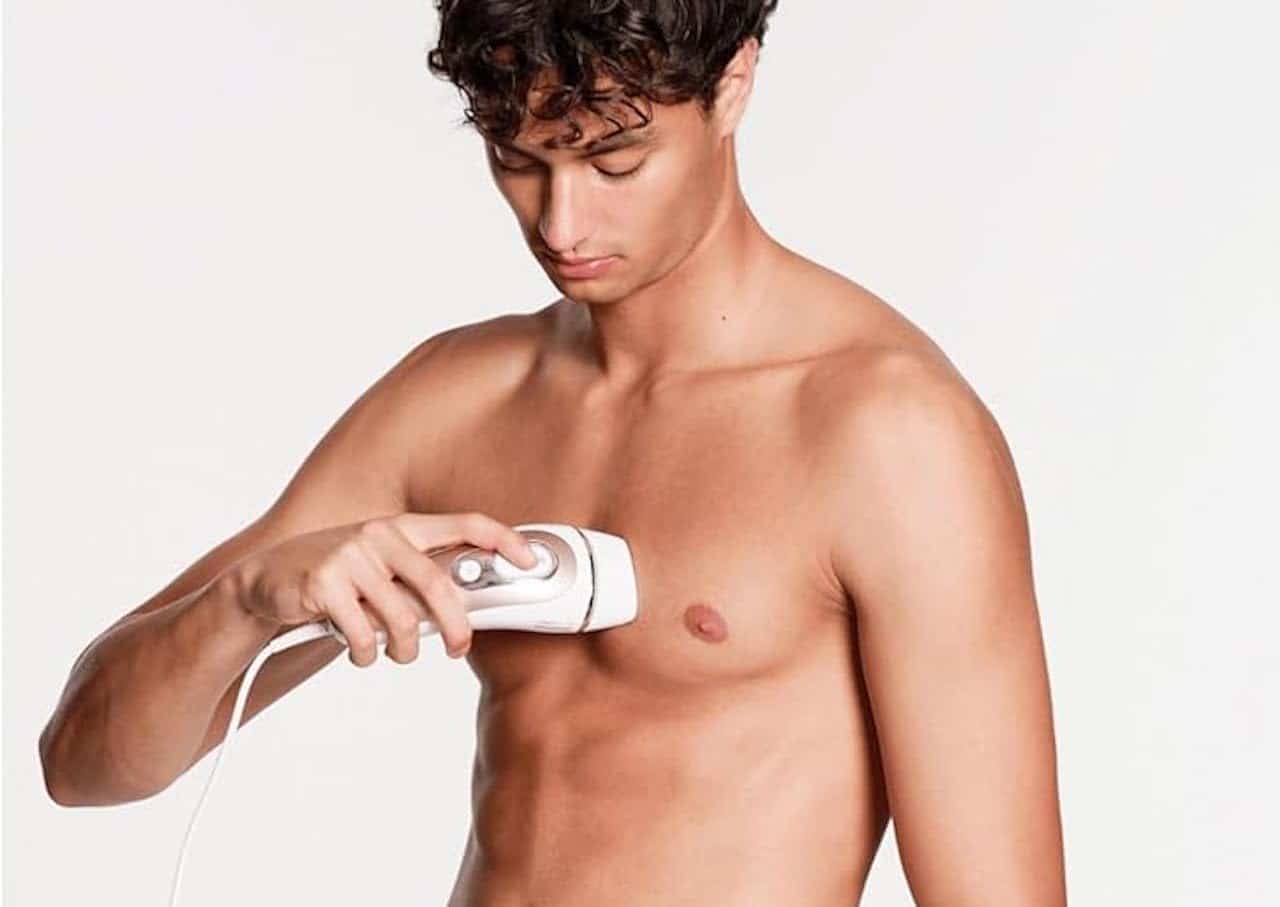 Un homme qui utilise un épilateur à lumière pulsée.