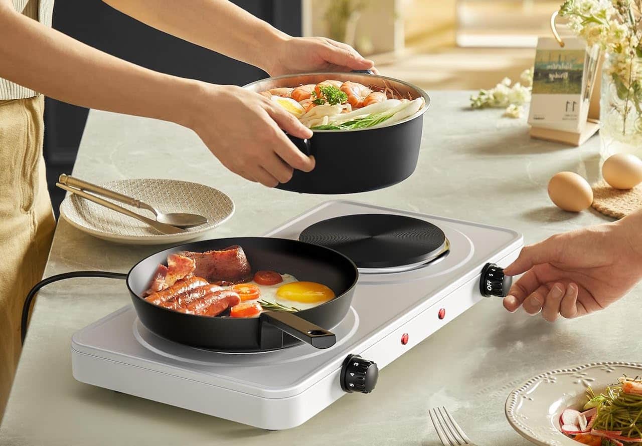 Des personnes qui utilisent un réchaud électrique pour cuisiner.
