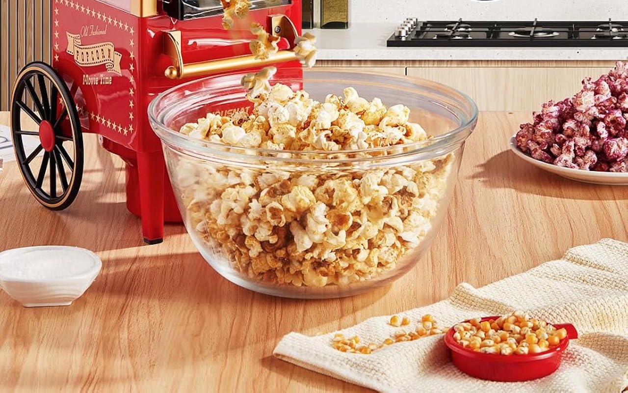 Un bol de pop corn à côté d'une machine à pop corn.