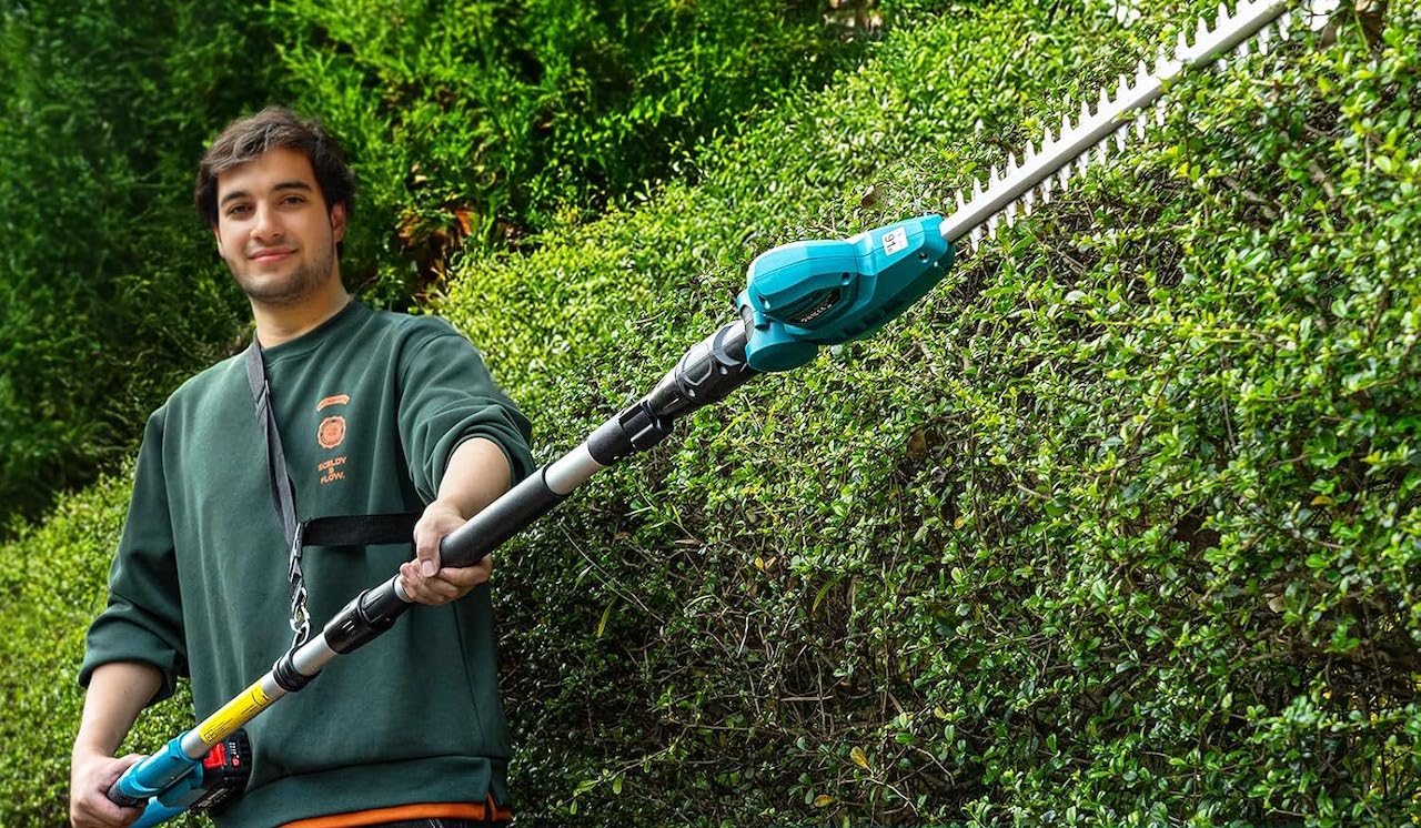 Un homme qui utilise un taille-haie électrique.