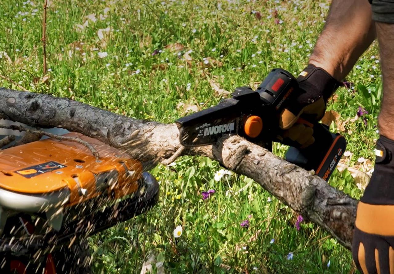 Un homme qui utilise une élagueuse pour couper du bois.
