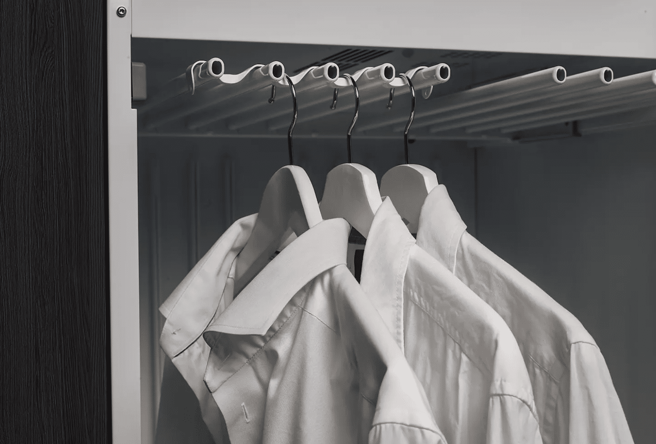 Trois chemises blanches disposées dans une armoire séchante.