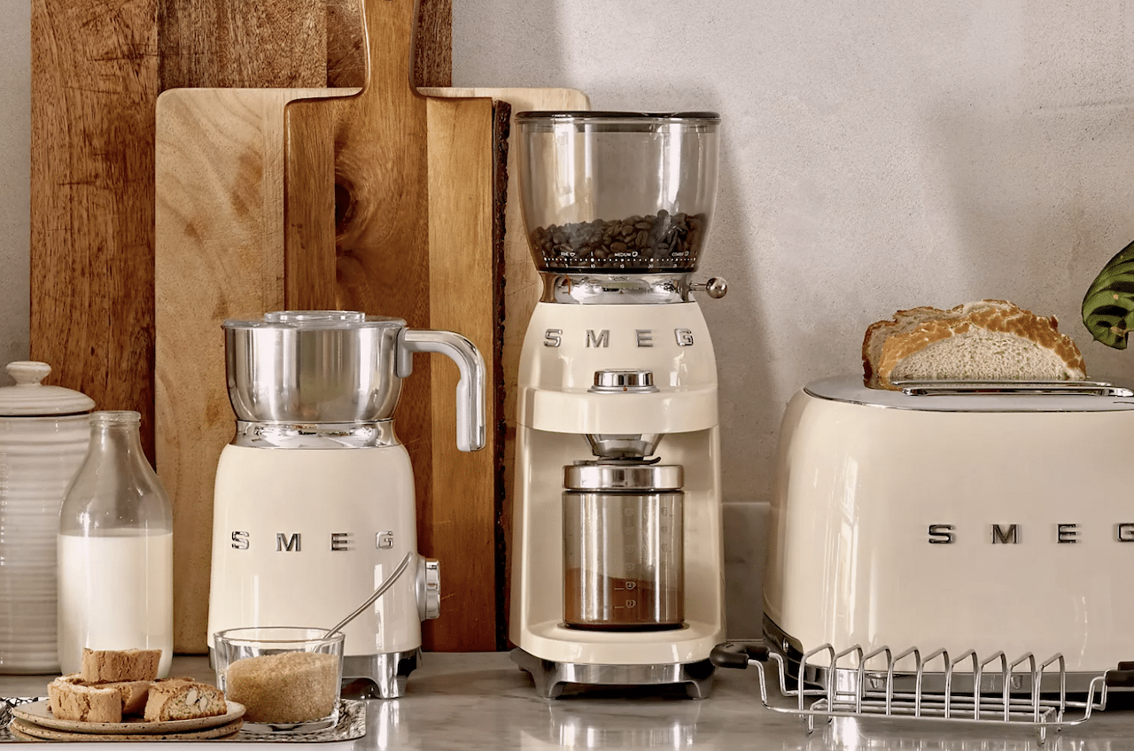 Un moulin à café électrique de la marque Smeg sur un plan de travail.