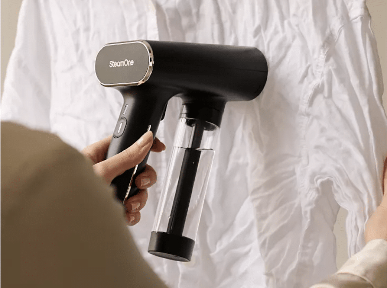 Une femme qui utilise un défroisseur vapeur sur une chemise blanche.