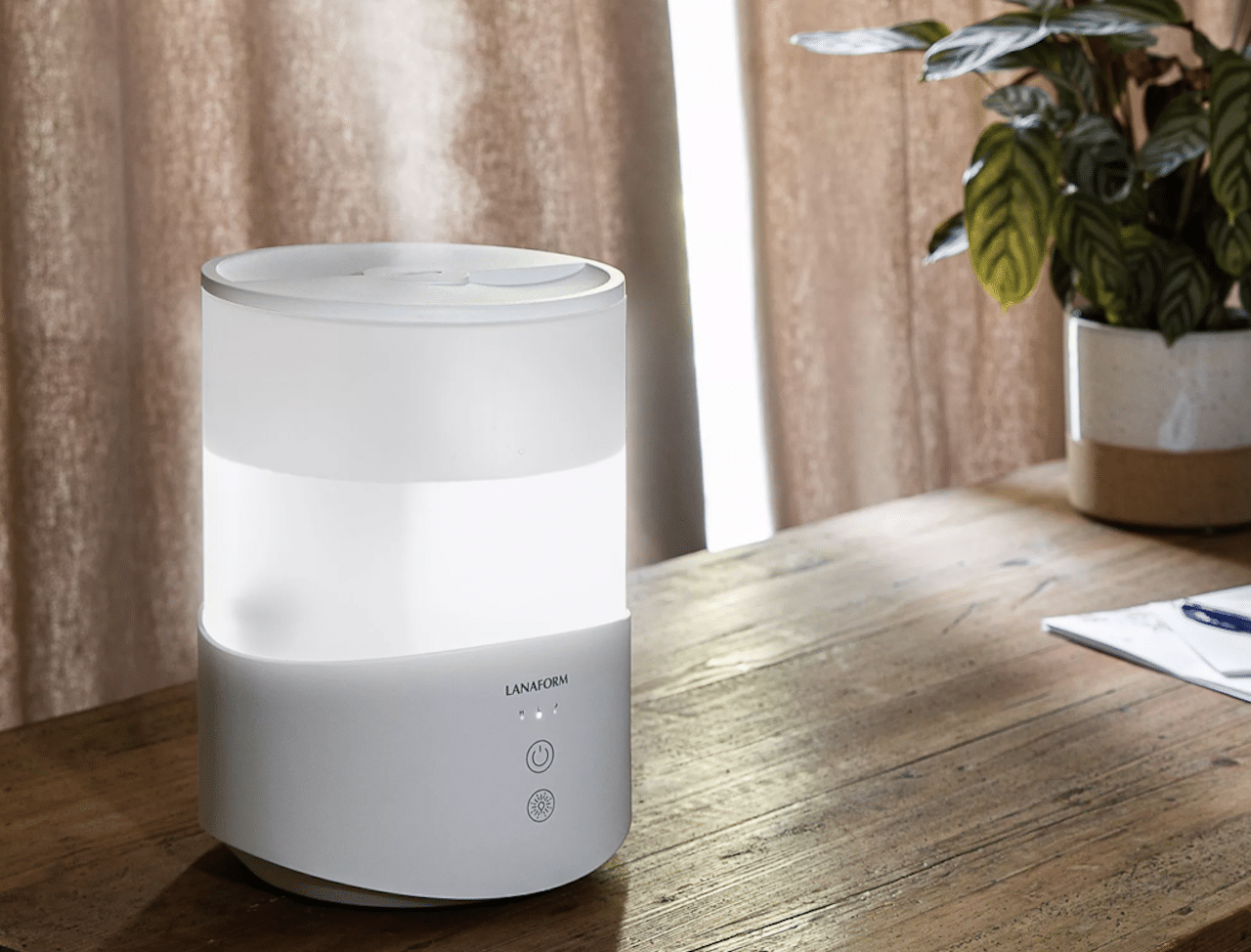 Un petit humidificateur d'air posé sur une table en bois.
