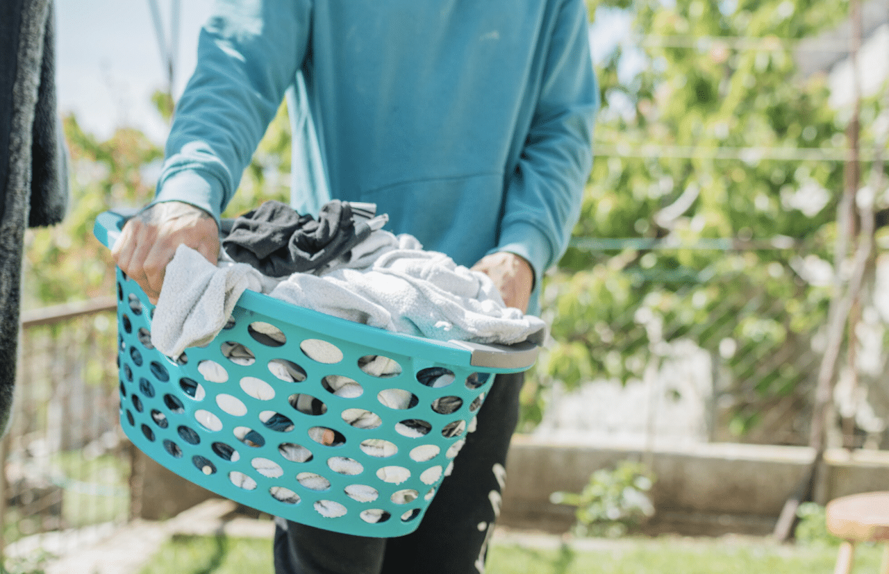 Une homme qui porte un panier à linge.