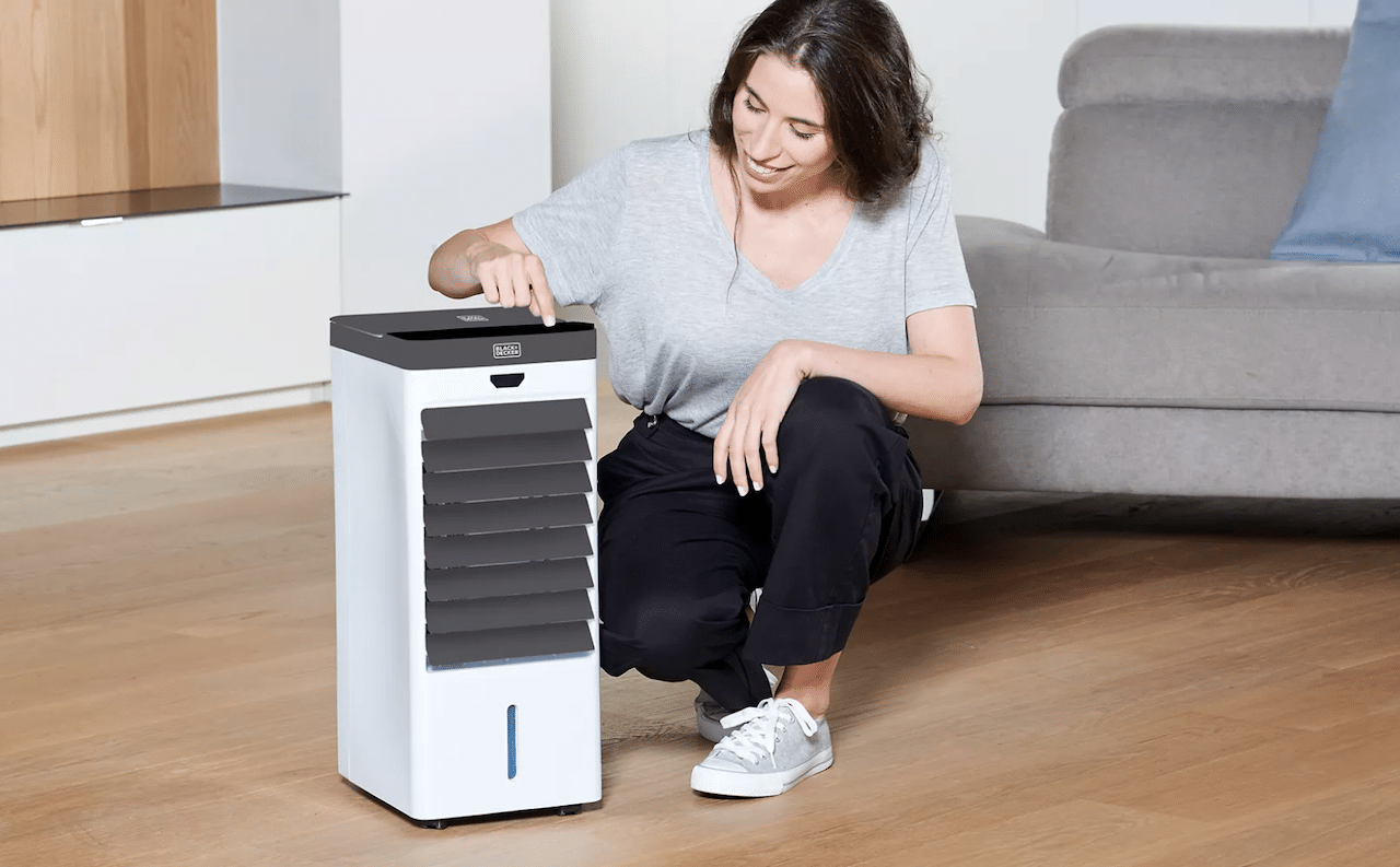 Une femme qui utilise un rafraîchisseur d'air pour son salon.