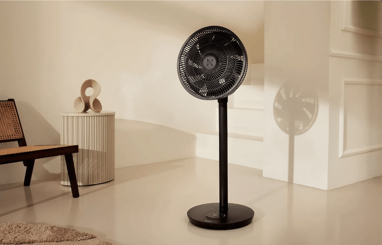 Un ventilateur sur pied noir dans un salon.