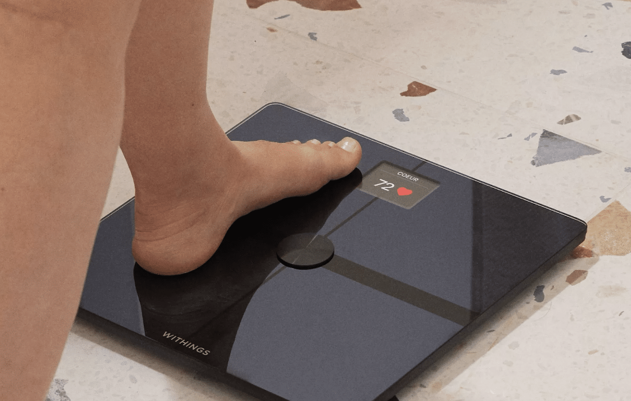 Une femme qui utilise un pèse-personne.