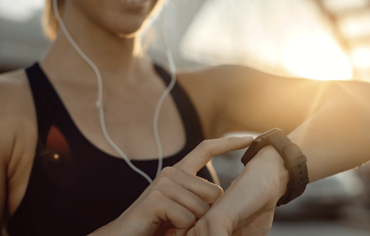 Une femme qui fait du sport et utilise un bracelet connecté.