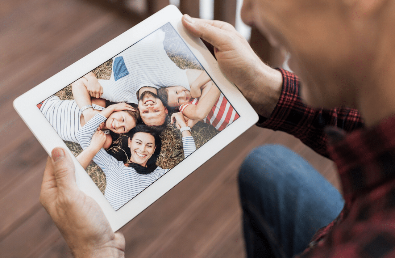Un homme qui regarde une photo sur un cadre photo numérique.