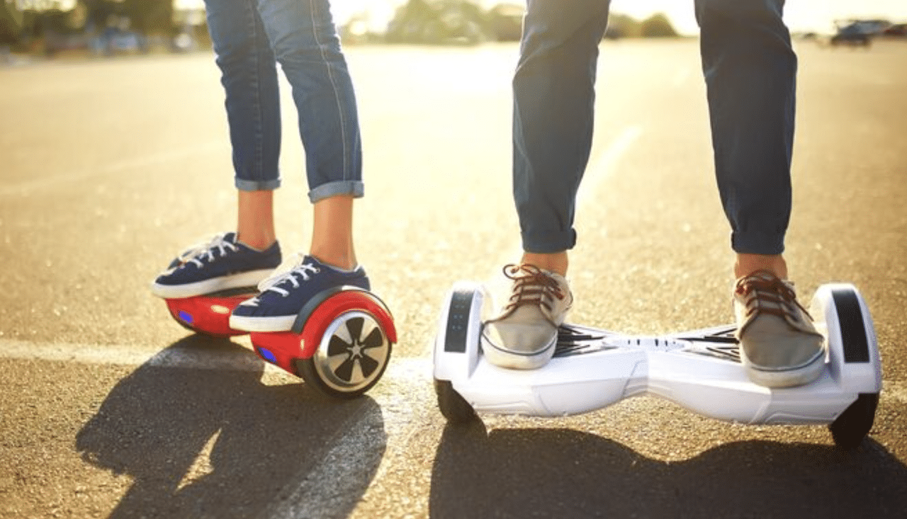 Deux personnes qui utilisent des hoverboards en extérieur.