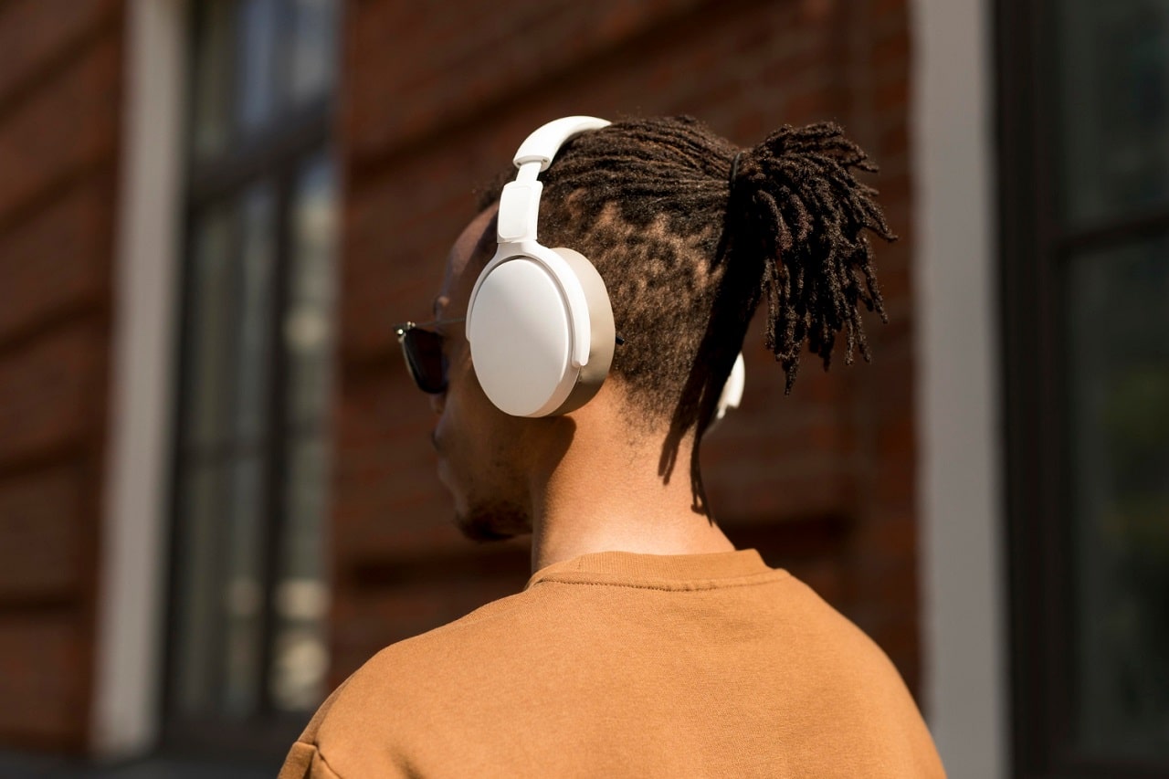 Un homme de dos portant un casque audio blanc sur la tête