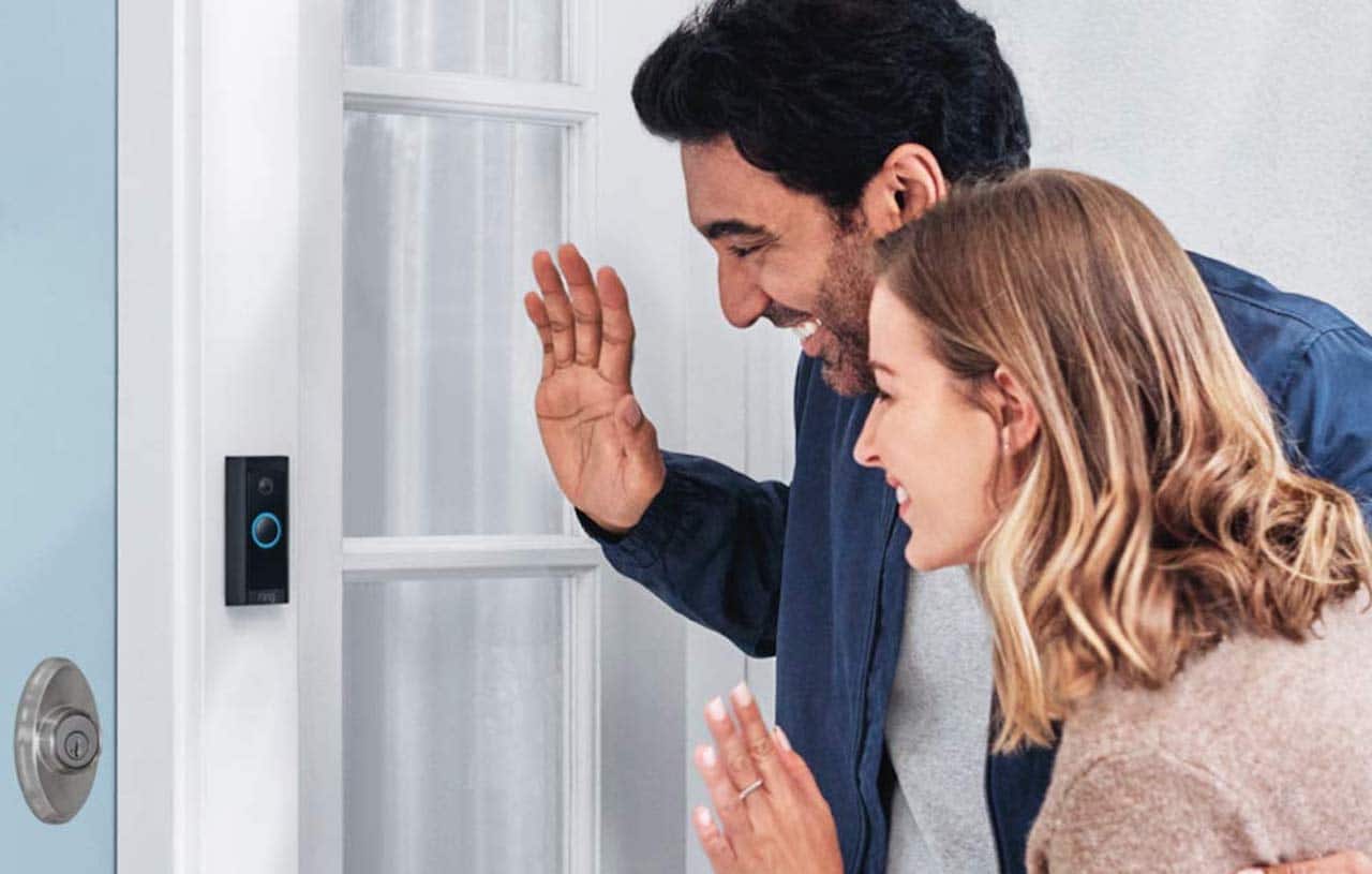 Un couple qui se tient devant un visiophone.