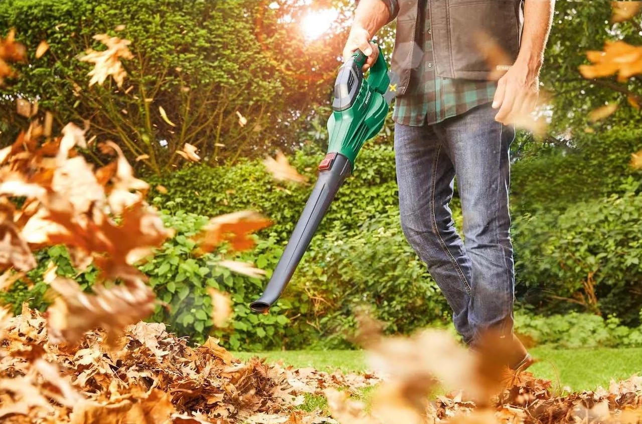 Un homme qui utilise un souffleur de la marque Parkside dans son jardin en automne.