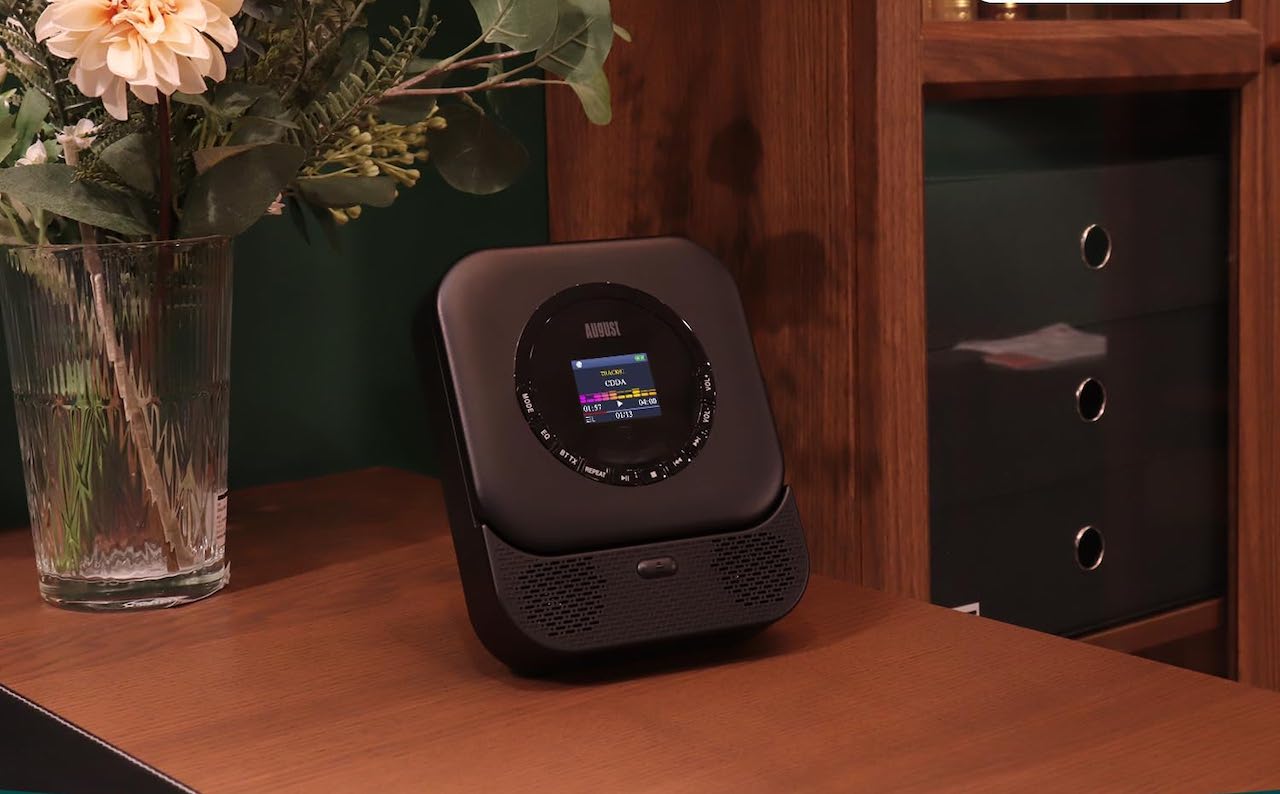 Un lecteur CD posé sur une table de chevet en bois.