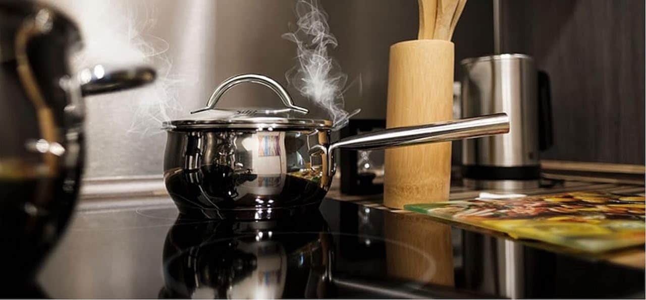 Une casserole qui chauffe sur une plaque à induction de la marque GEDTECH.