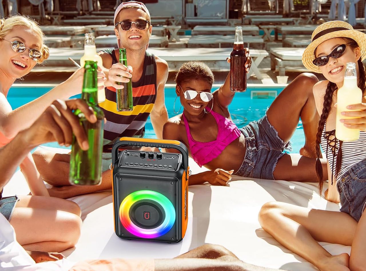 Une groupe d'amis qui utilisent un lecteur karaoké au bord d'une piscine.