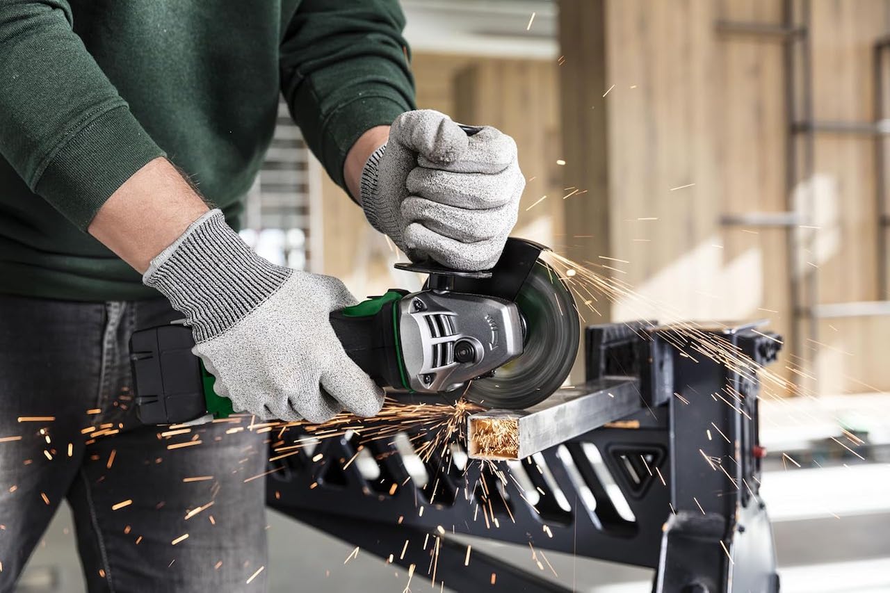 Un artisan utilise une meuleuse de la marque HiKOKI.