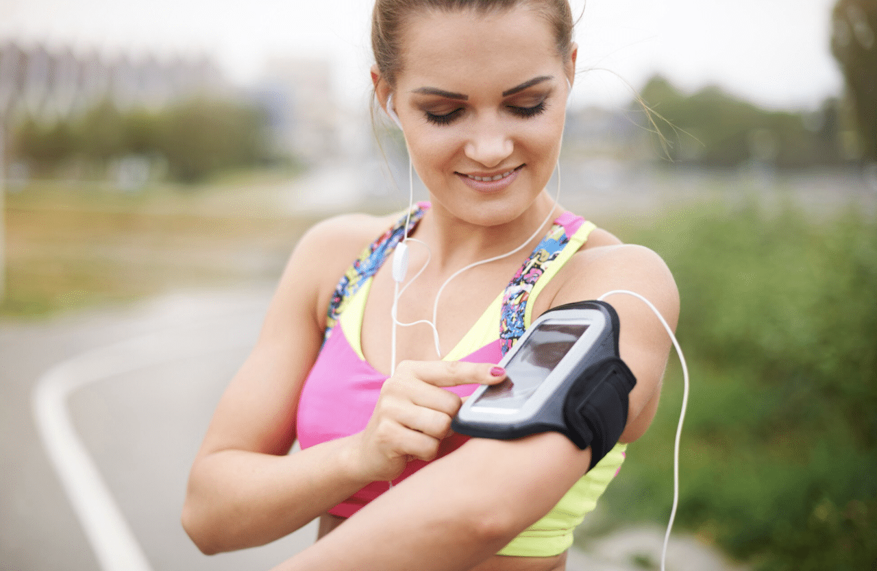 Une femme qui cours et qui utilise un podomètre.