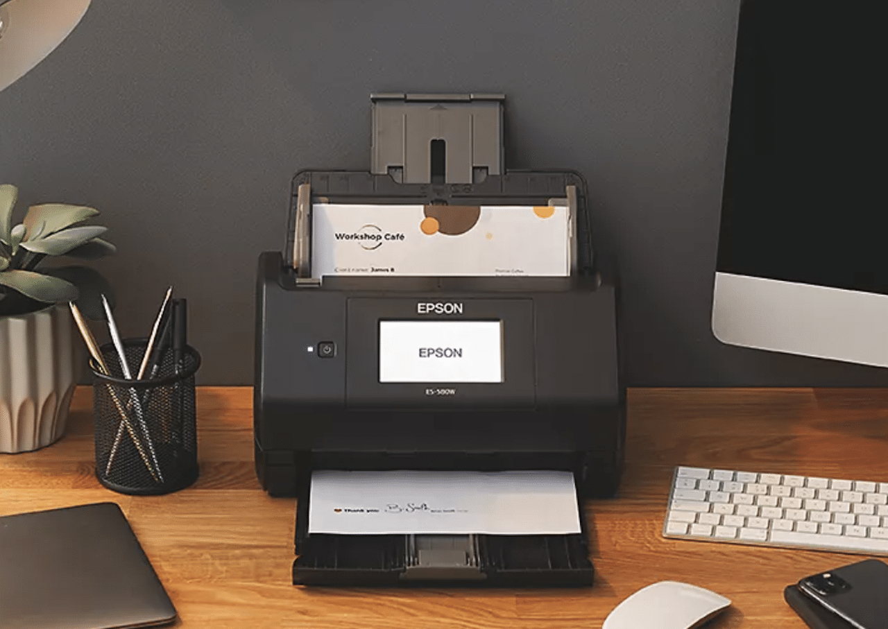 Un scanner de la marque Epson sur un bureau en bois.