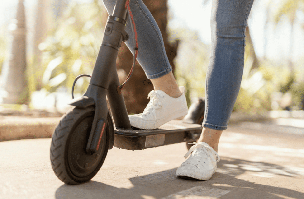 Une femme qui est sur une trottinette électrique.
