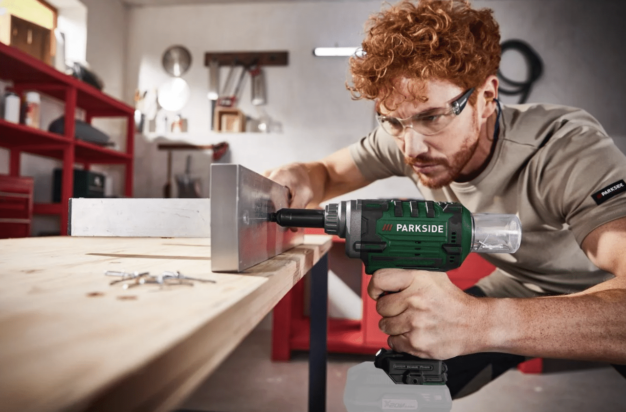 Un homme qui utilise une riveteuse de la marque Parkside pour bricoler.