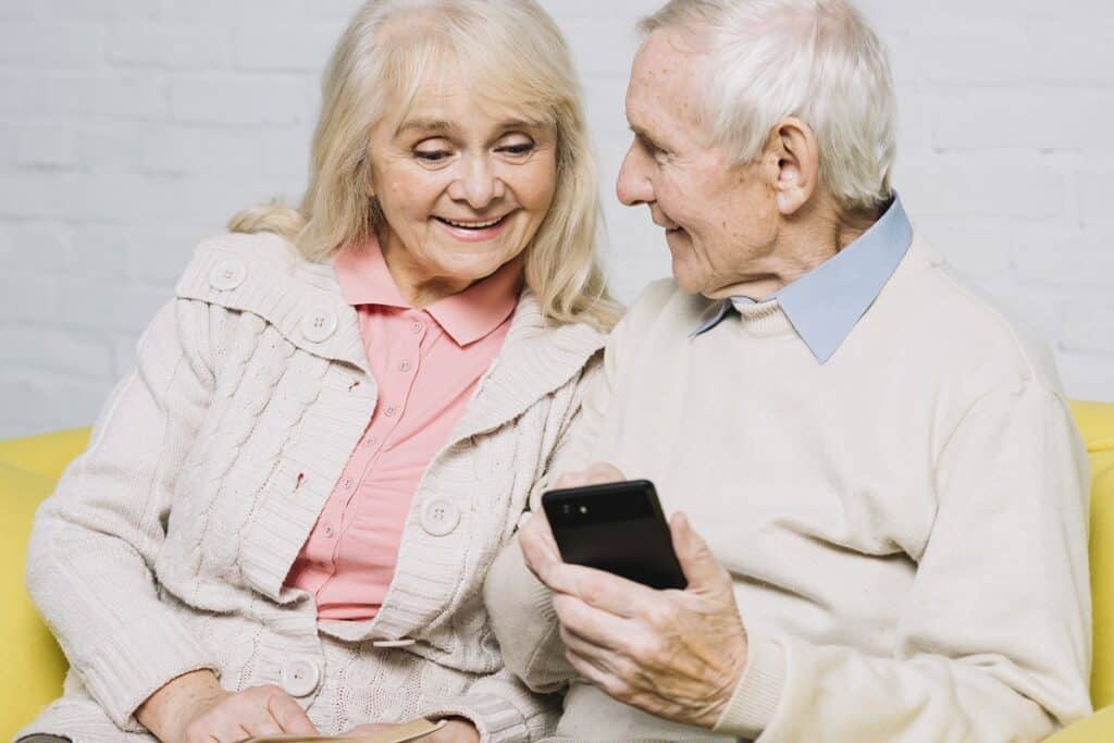 Un couple de personnes âgées utilisant un smartphone