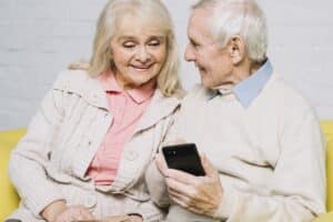 Un couple de personnes âgées utilisant un smartphone