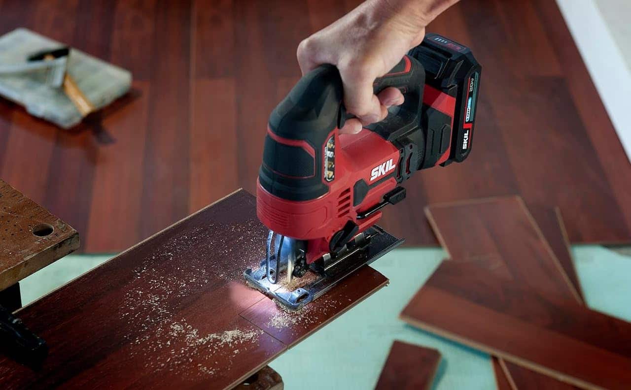 Une personne qui utilise une scie sauteuse de la marque SKIL.