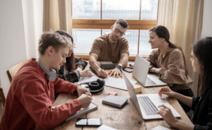 Des étudiants autour d'une table qui travaillent sur leurs cours.