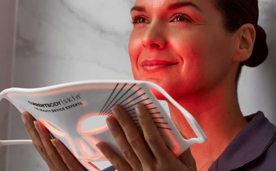 Gros plan sur le visage d'une femme retirant son masque LED Therabody à lumière rouge