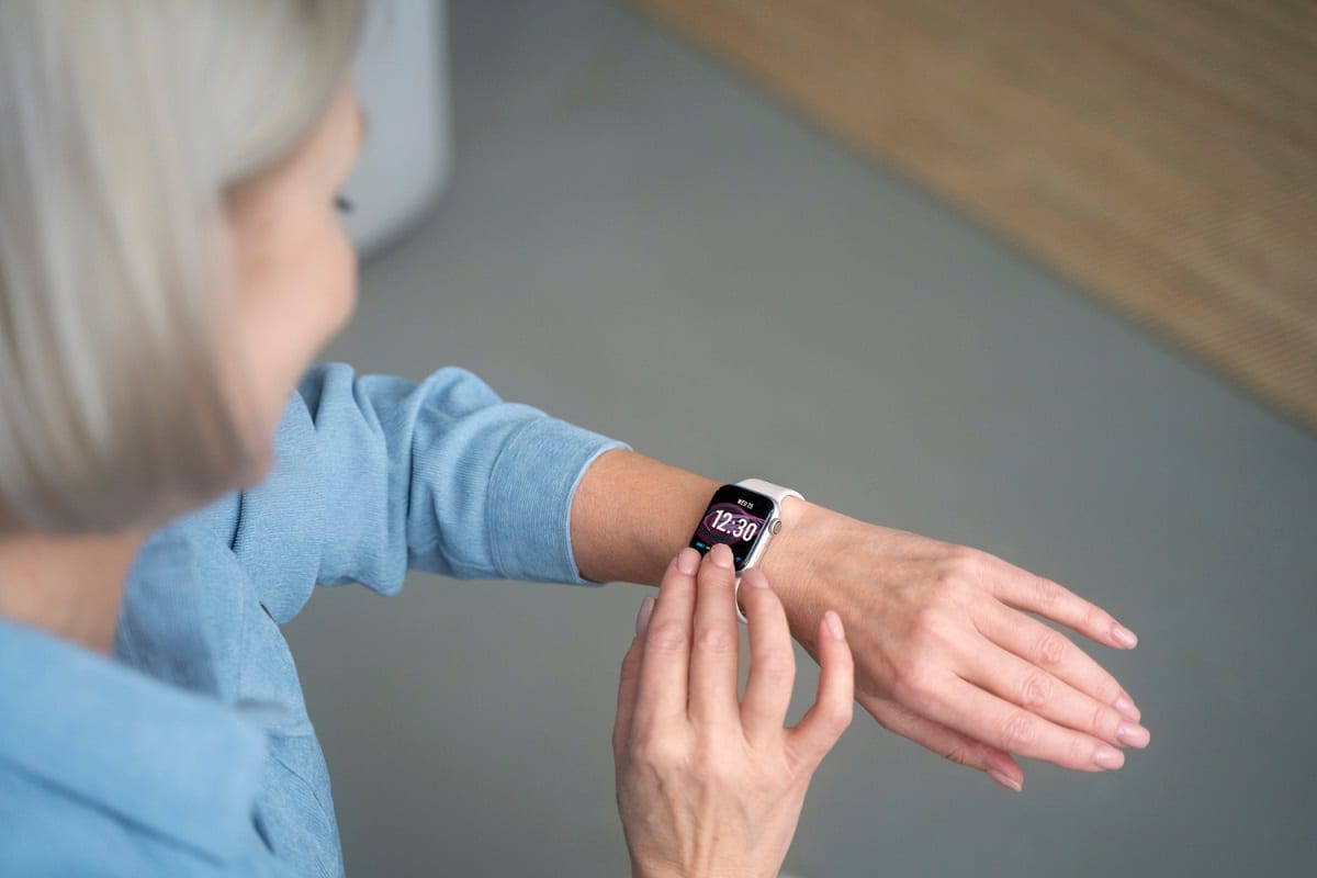 Une femme âgée utilisant une montre connectée pour senior