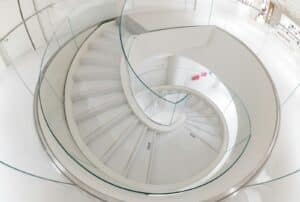 A modern, white, spiral staircase is pictured.