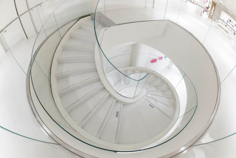 A modern, white, spiral staircase is pictured.