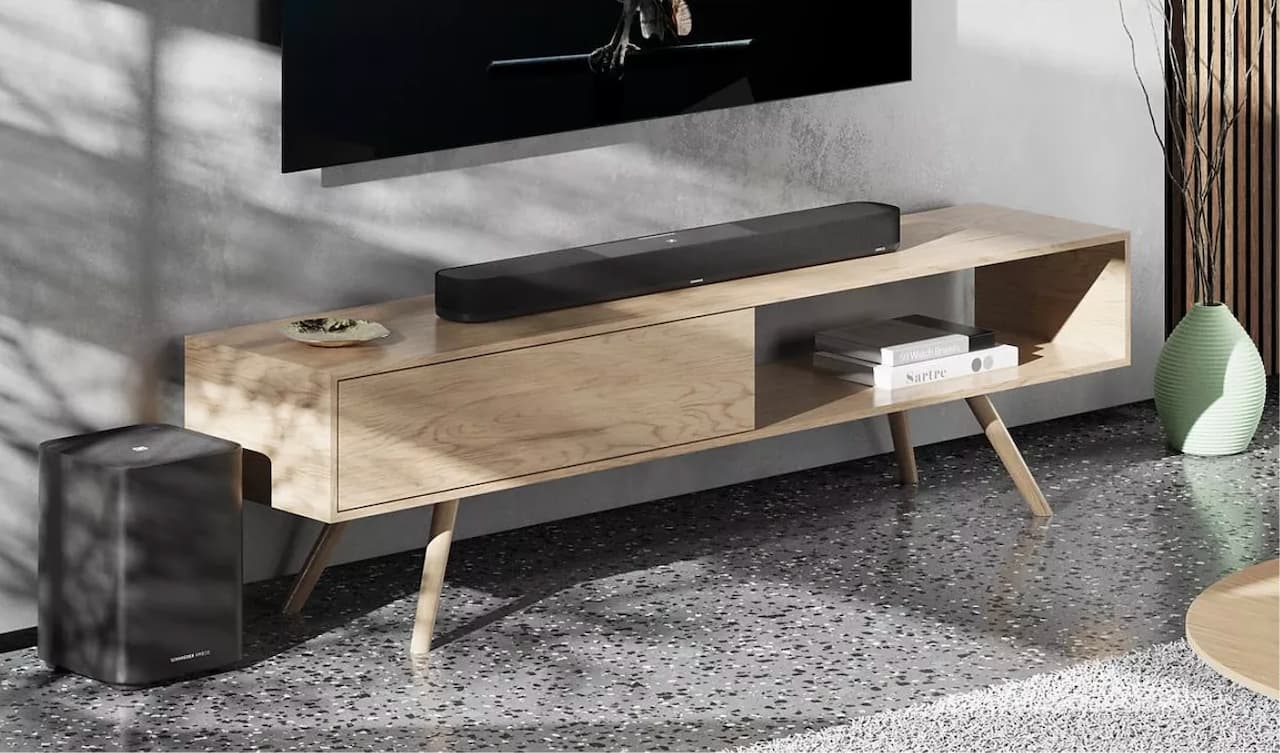 Une barre de son Sennheiser sur un meuble TV moderne.