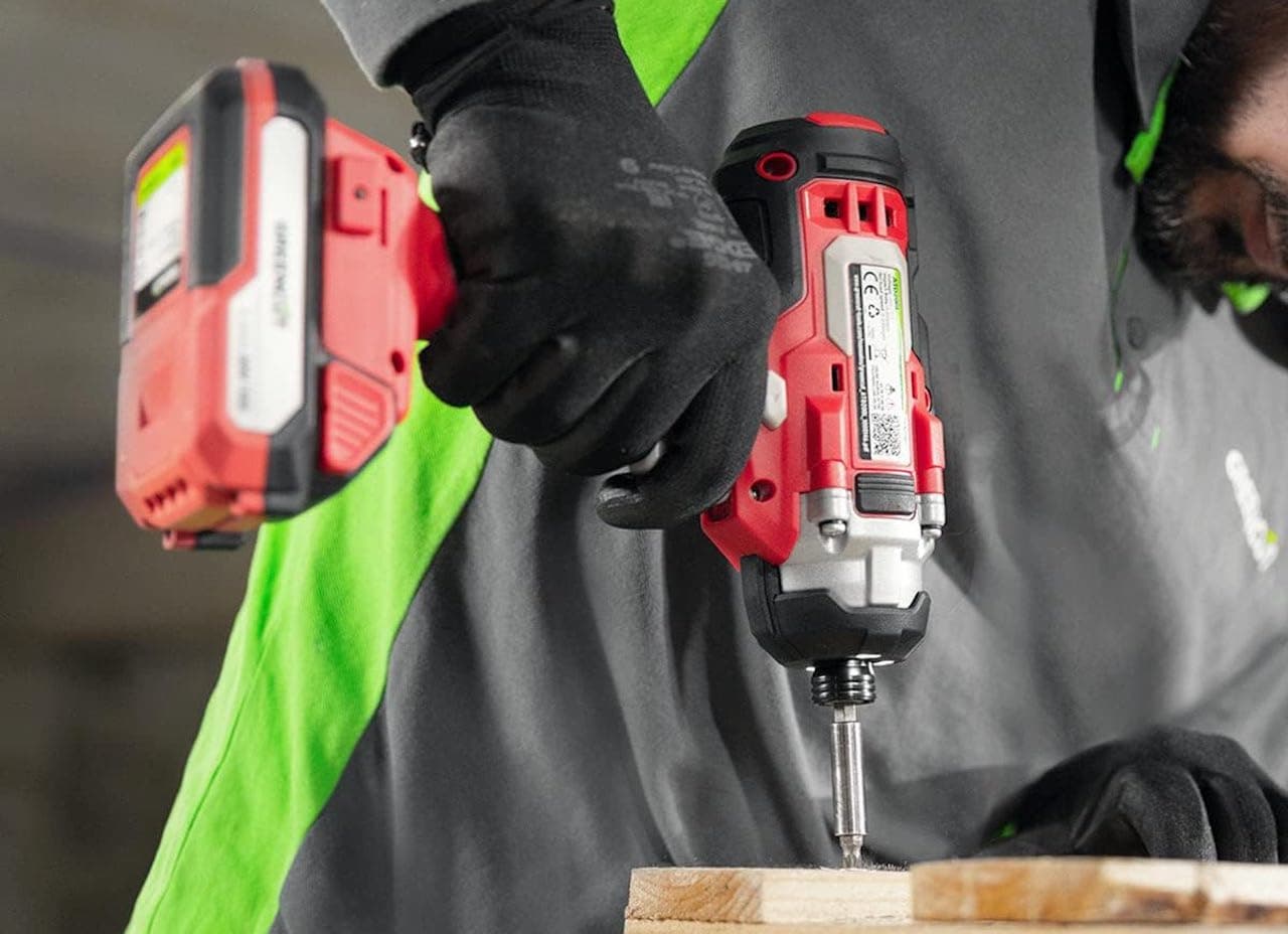 Une personne qui utilise une perceuse de chez Greencut sur du bois.
