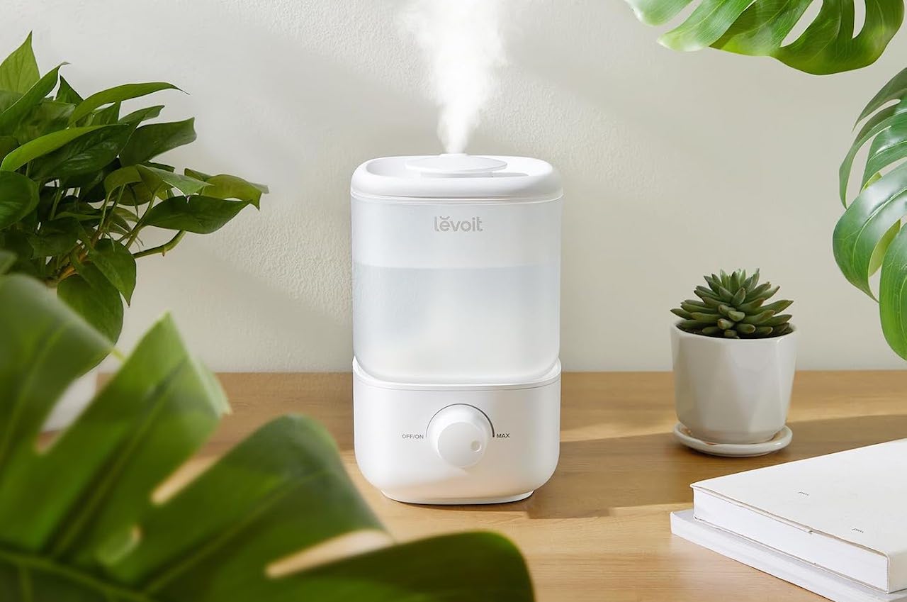 Un humidificateur de la marque Levoit posé sur une table en bois.