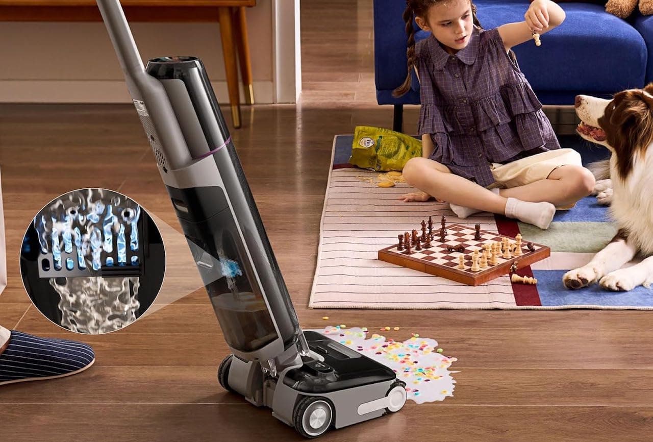 Une personne qui utilise un aspirateur balai laveur de la marque EUREKA sur un parquet sale.