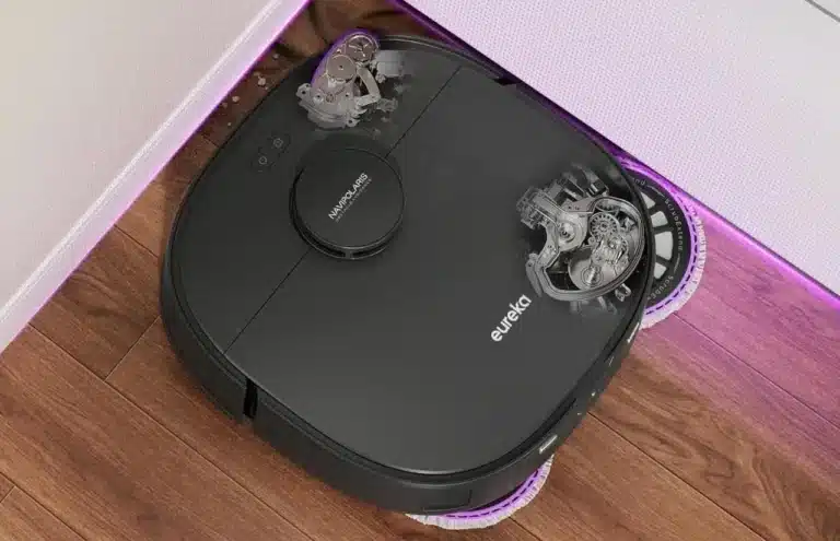 Gros plan sur un aspirateur robot Eureka vue du dessus dans l'angle d'une pièce