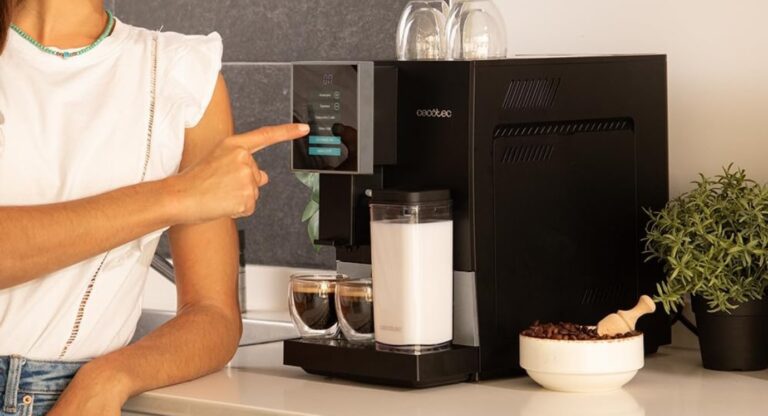 Une jeune femme appuyant sur l'écran tactile de sa machine à café Cecotec Cremmaet Compactccino