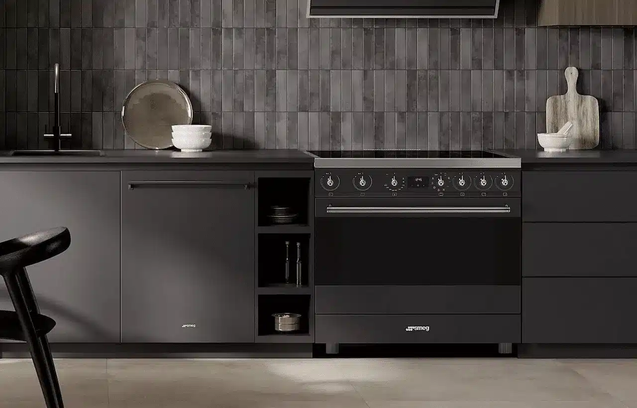 Une cuisinière encastrée dans une cuisine moderne aux tons noirs