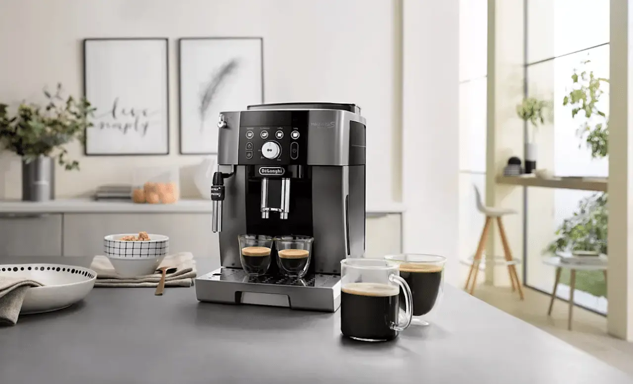 Une machine à café expresso broyeur posée sur un plan de travail avec devant 2 tasses à café fumantes.