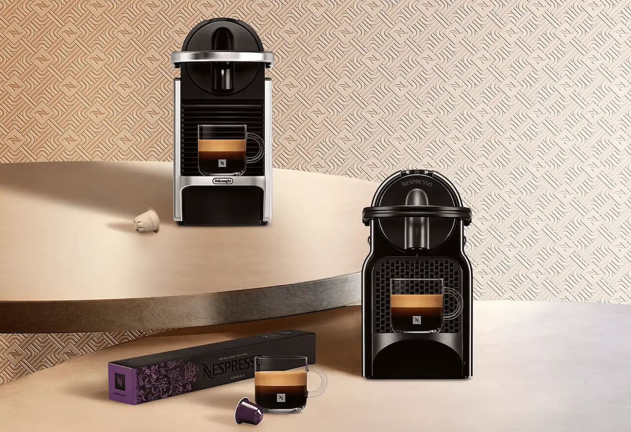 Deux machines à capsule Nespresso avec devant une boite de capsules Nespresso.