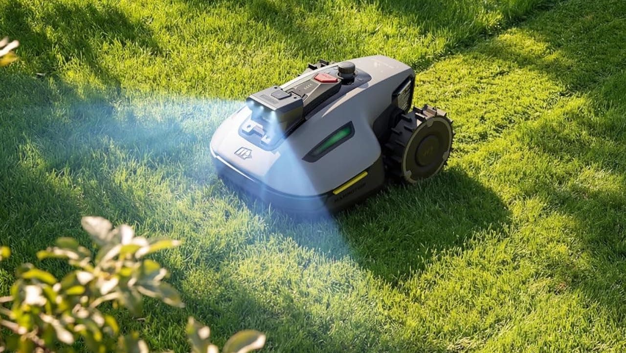 Un robot tondeuse de la marque Mammotion sur une pelouse en été.
