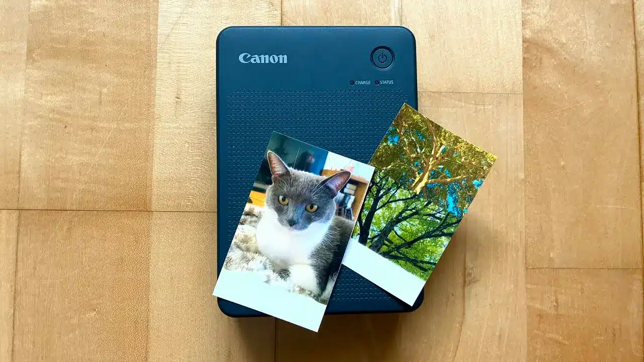 L'imprimante Canon Selphy QX20 avec 2 photos format carte de crédit posées dessus