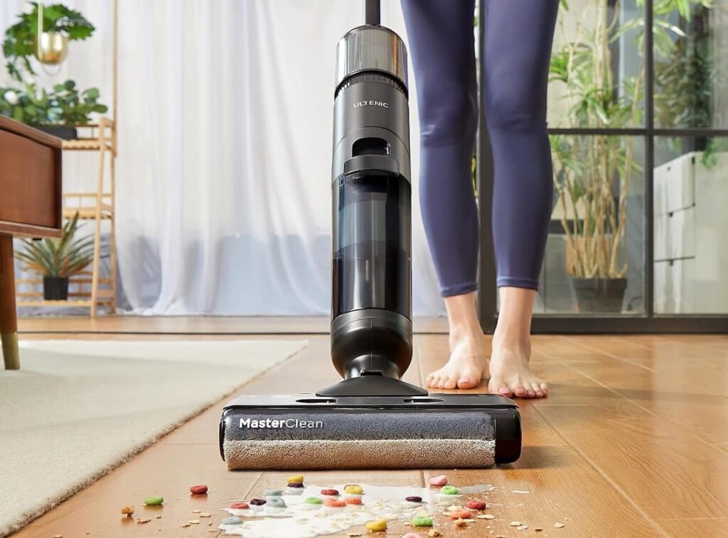 Zoom sur un aspirateur balai laveur de chez Ultenic qui nettoie un parquet.